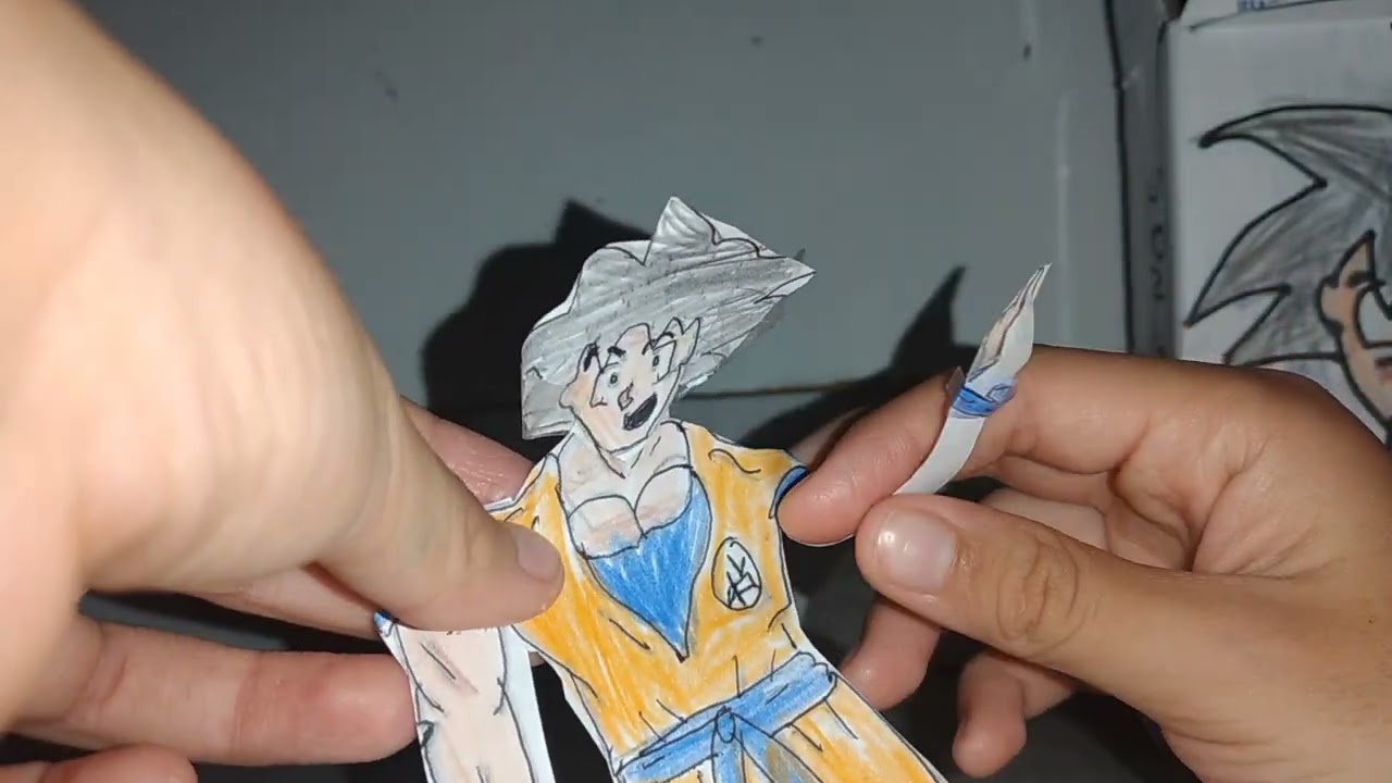 mostrando o boneco do Goku de papel que eu fiz.