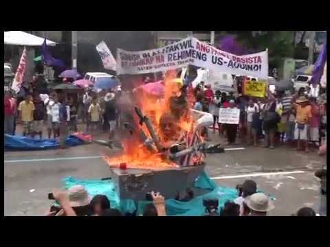 An effigy of President Benigno Aquino III with Uncle Sam behind him is burned by militant groups