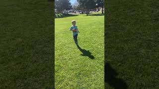 Boy runs with soccer ball then passes it to his Mom then she kicks ball and hits his face