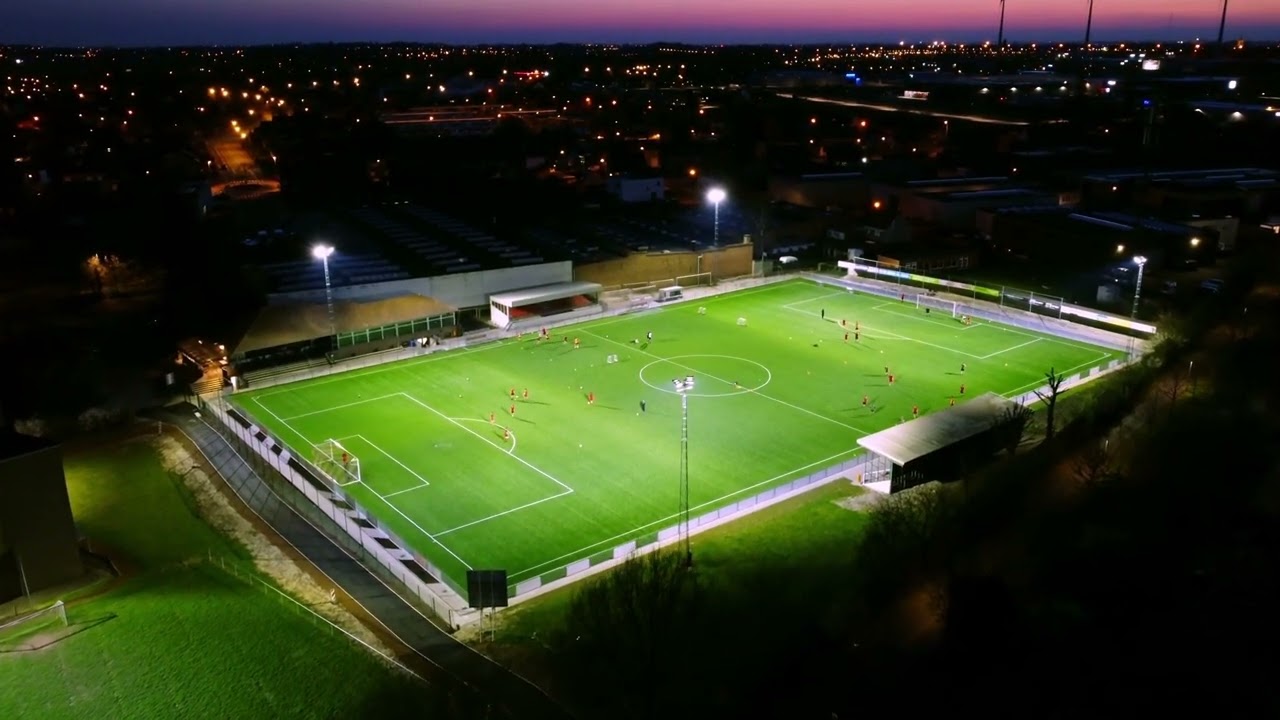 Dronebeelden van een door lichtmasten verlichte voetbalwedstrijd