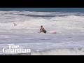 Teen lifeguard struggles to drag boy out of massive waves in California