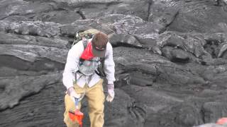 Geologist collects a fresh lava sample in Hawai'i in May 2014