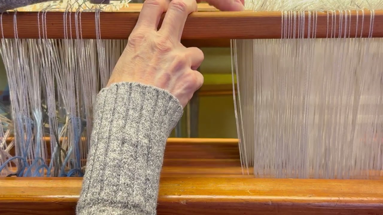 Продеваю основу сзади наперед, справа налево от середины