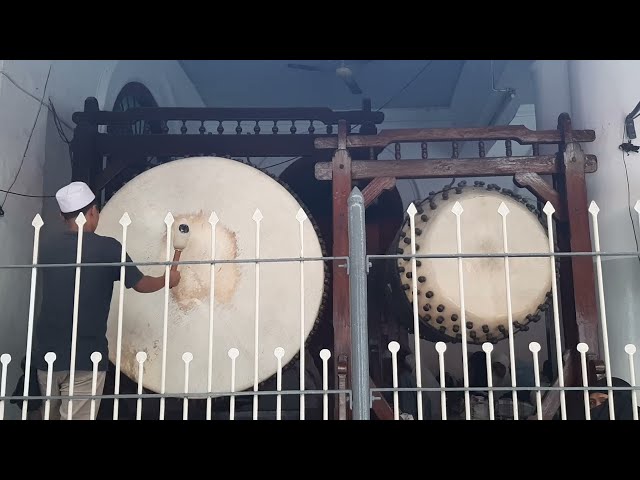 Traditional muslim call to prayer using bedug (huge drum from leather) in Indonesia class=