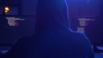 cybercrime hacking and technology concept male hacker in dark room writing code or using