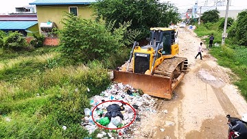 Incredible bulldozer operator clearing and pushing soil filling land with dump trucks