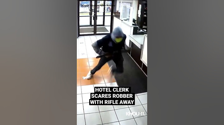 A hotel clerk scared away a robber carrying a rifle when she threatened him with her own gun.
