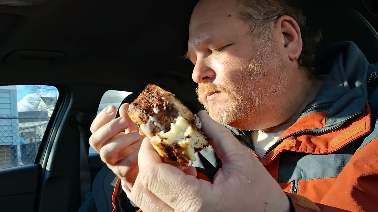 Derek Shapiro Eating A Cinnamon Bun In The Car From: Panaderia El Quetzal
