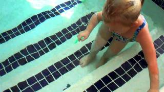 Natalie dives underwater to pick up toys