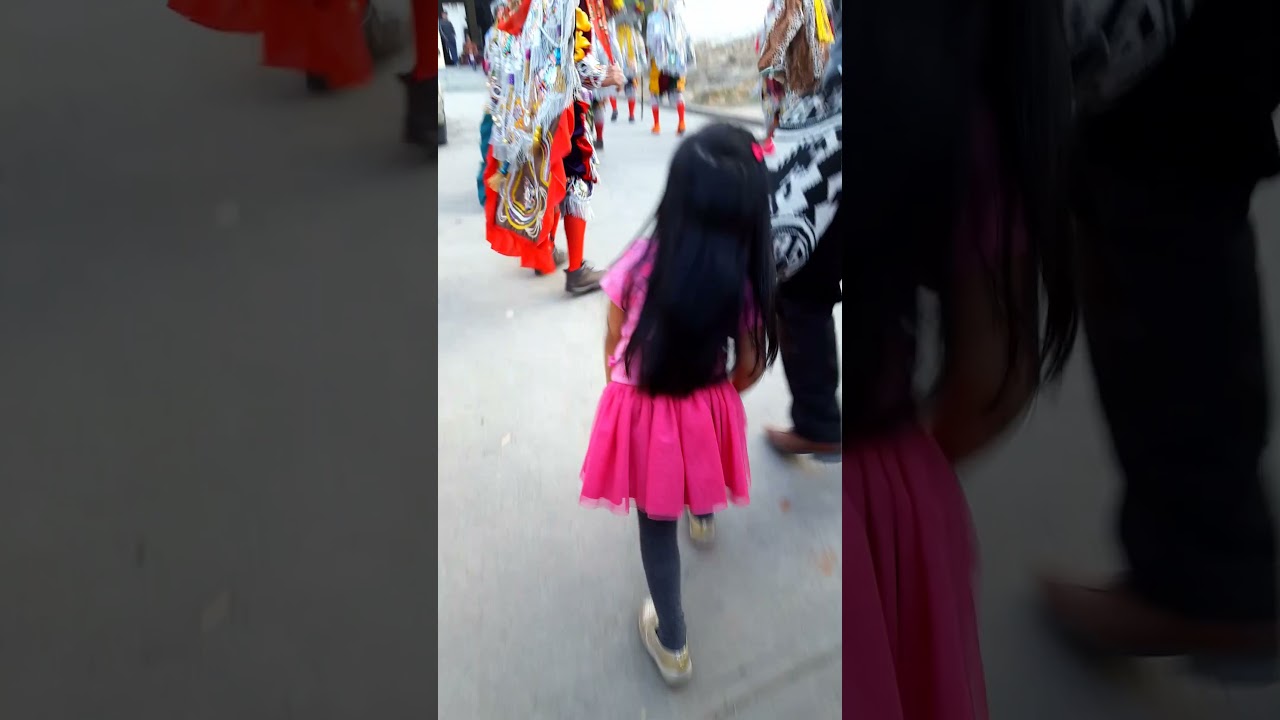 Little girl shadowing Torito dancers in Guatemala 