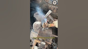 The blacksmith fitted the handle of a forged short handled axe