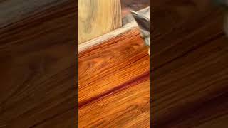 applying wood stain with a soft sponge to enhance the natural grain and deep colors of the timber