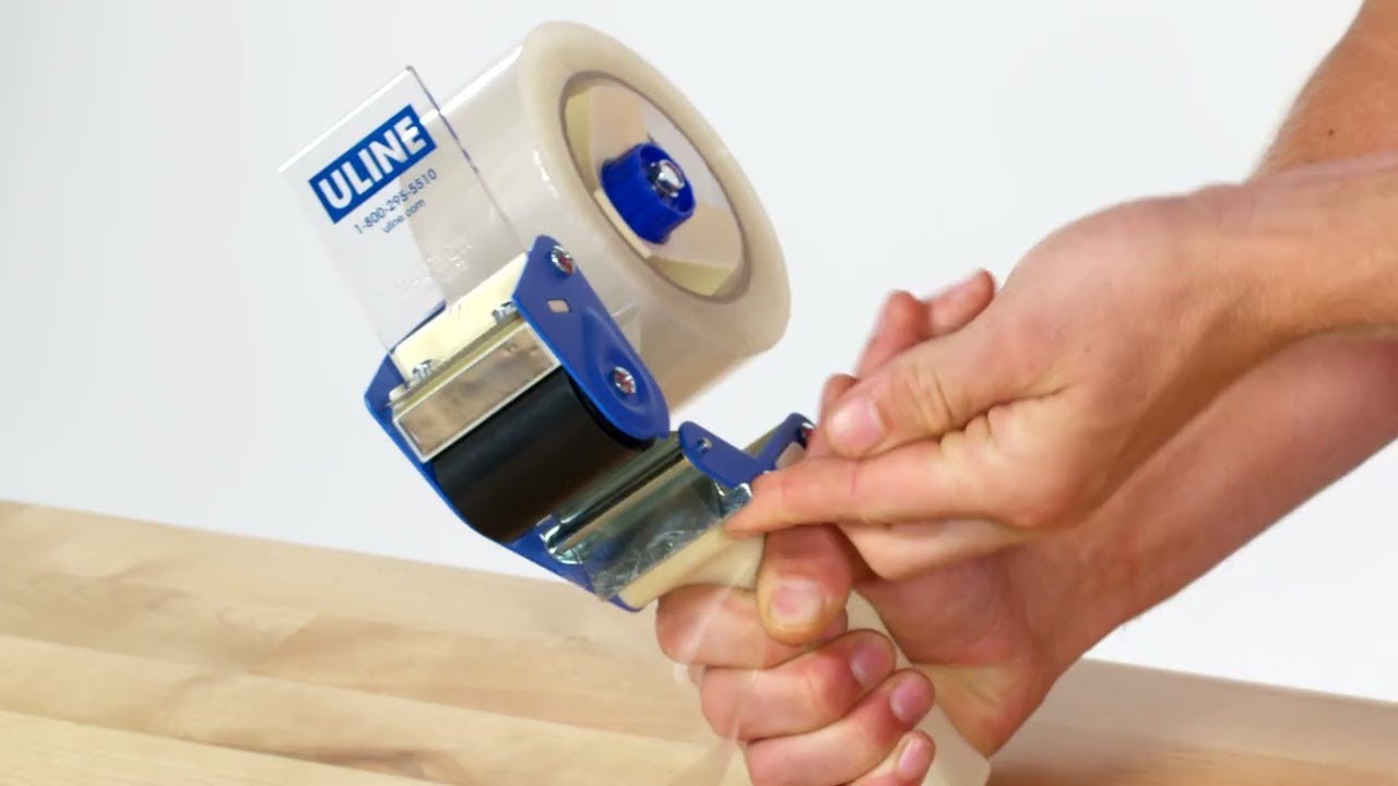 Premium Photo | Worker works with tape dispenser, closing cardboard  industrial box