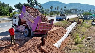 Dropping soil to bury drainage next to the road. Drivers passing by must be very careful.
