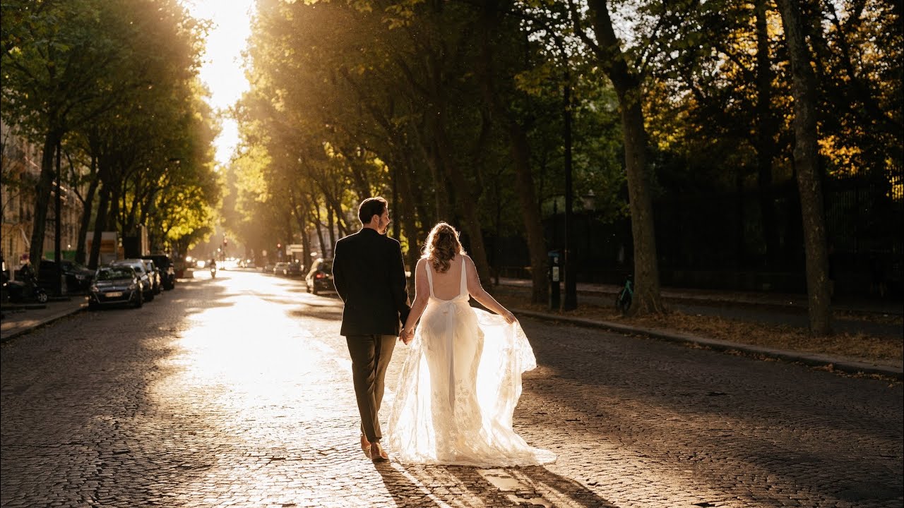 Bride and groom walk hand in hand down a tree-lined Paris street in golden sunset light