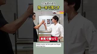 The aikido master lets him grab one finger and drops him.