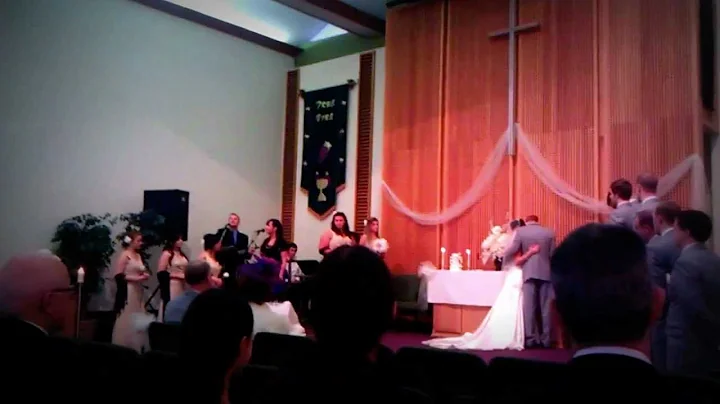 Sam and Sarah Rawley taking communion at their wed...