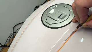 Hand pinstriping a BMW tank