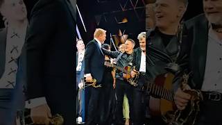 Bryan Adams & Kevin Costner Hug Each Other At An Event