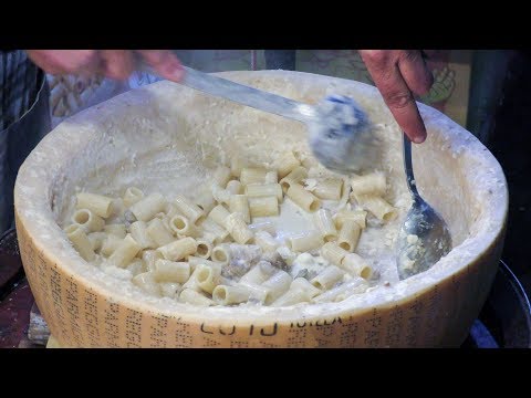 Italian Pasta Drowned in a Huge Parmigiano Cheese Wheel. Street Food Seen Near Milano