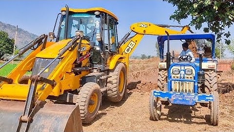 3DX JCB Backhoe Loader Machine Loading Mud In New Swaraj 744 XT Tractor In Village