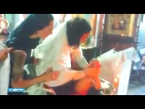 Video: Priester Slaat Een Baby Bij Zijn Doop