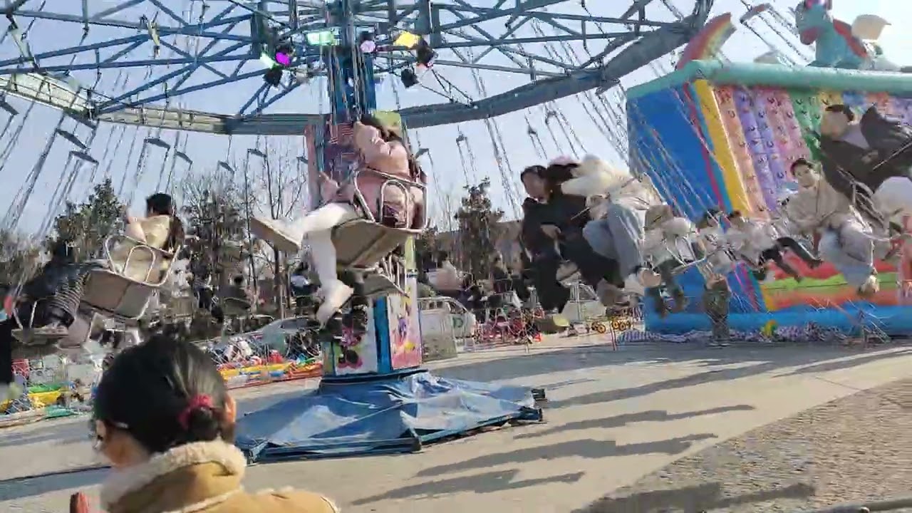 中国　江蘇省　農村　春節　正月　お祭り　移動遊園地　伝統文化　伝統行事　年中文化　子供　遊び　憩い　楽しみ　メリーゴーランド　ジェットコースター　回転ブランコ　輪投げ　崖のぼり　懸賞　プール