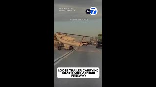 Loose trailer carrying boat darts across freeway