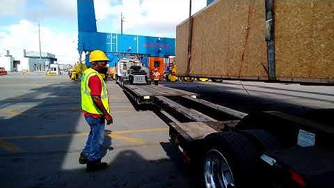 loading a big crate on a stretch lowboy