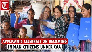 Applicants celebrate after receiving CAA certificates from Union home secretary in Delhi