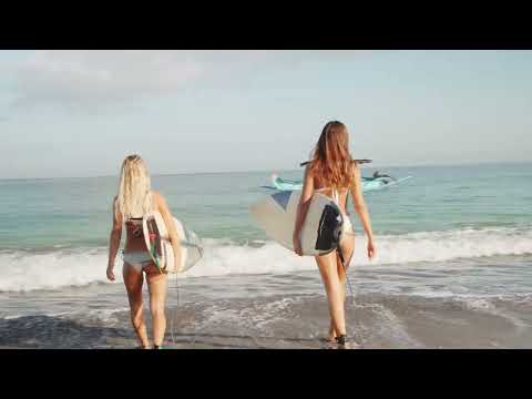 two unrecognizable young women with sporty bodies wearing bikinis holding surfboard 4K