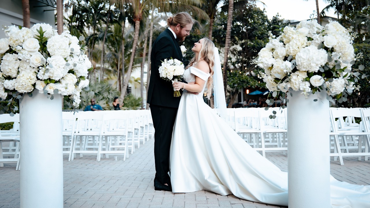 Andrea and Hunter laugh during a playful wedding portrait between white floral arrangements at their Riverside Hotel wedding in Fort Lauderdale, Florida