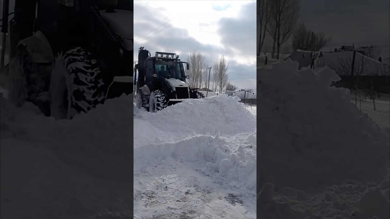 EXCAVATOR CLEARS SNOWY ROADS.