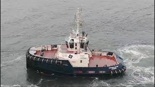 Tugboat picks up a bulk carrier at sea and escorts it thru the waters near IJmuiden. Tugboat picks up a bulk carrier at sea and escorts it thru the waters near IJmuiden.
