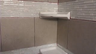 Part of the tiling process in the shower includes corner shelves for whatever you might need while you