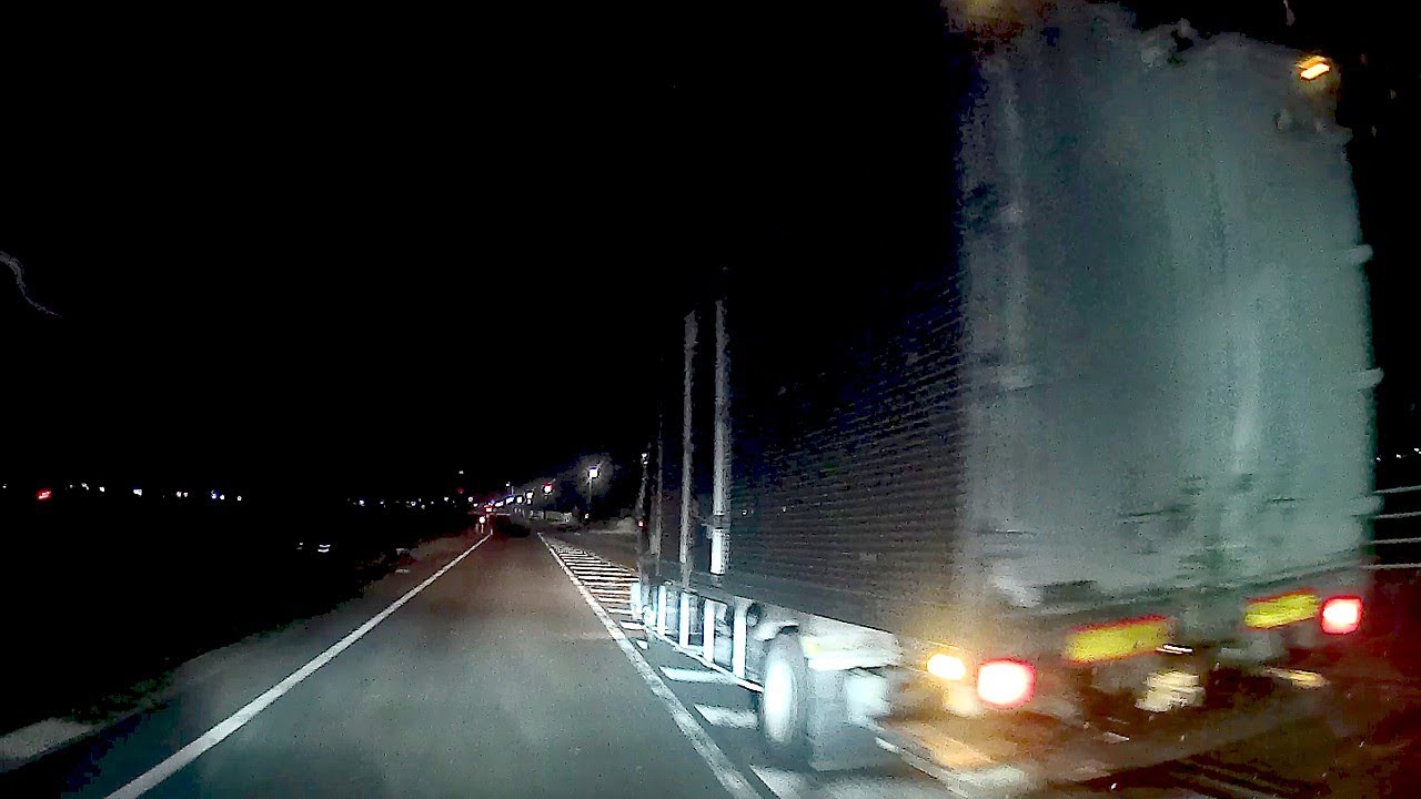 猛スピードで追い越しをするトラック