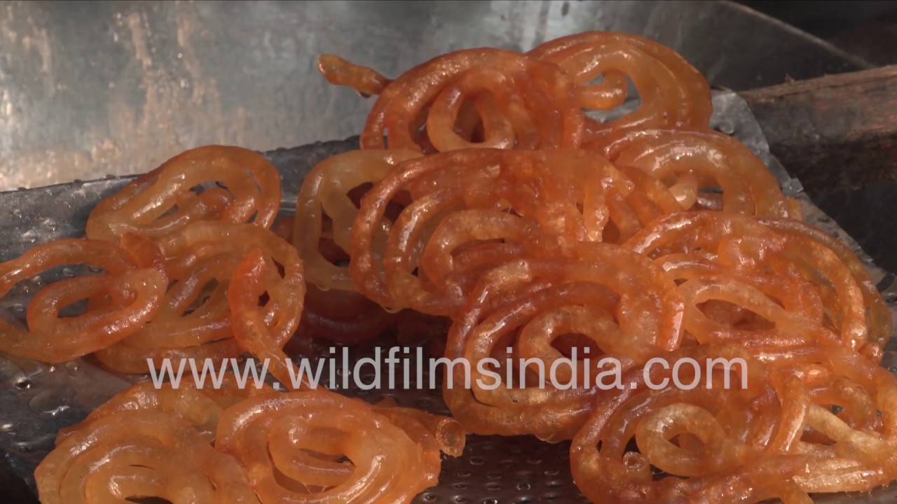 sugar syrup for bees Jalebi deep fried Indian sweets swim in pan of hot oil