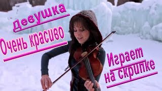 Девушка со скрипкой в ледяных скалах очень красиво играет.
