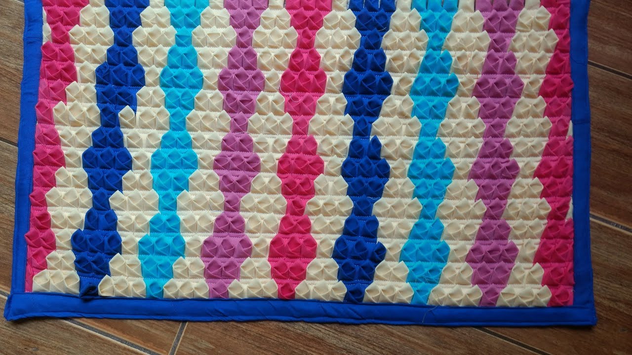 TAPETE DE RETALHOS DE TECIDOS COM BIQUINHOS EM FORMA DE LOSÂNGULOS