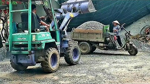 Máy xúc Komatsu múc vật liệu xây dựng lên công nông ba bánh