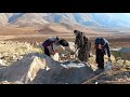 A pregnant woman with two children is working in the cold winter weather to shelter and borrow mater