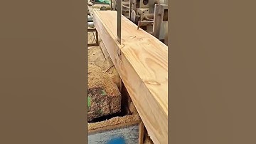 Bandsaw machine cutting wooden plank into smooth sections