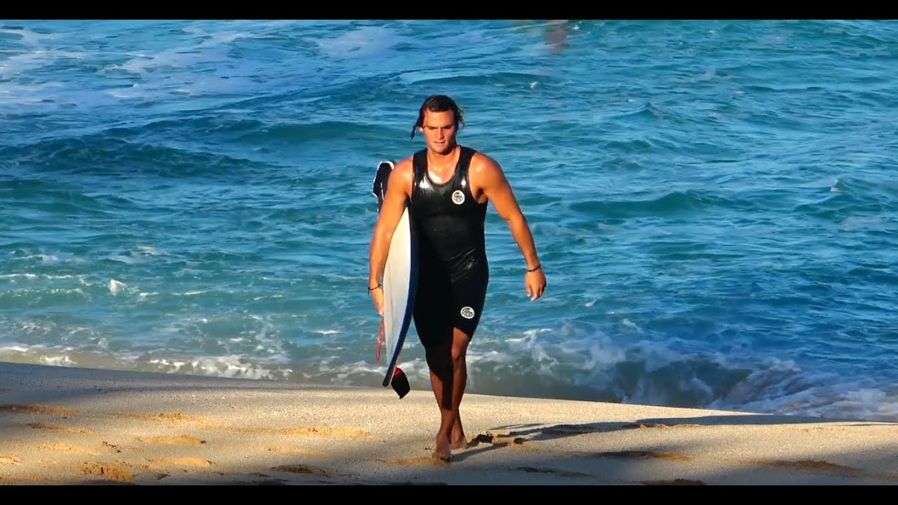 Marco walking out of the water with his board