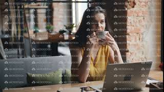 Relaxed Young Woman Drinking Coffee Sitting At Table In Cafe Alone With Laptop