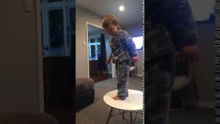 Boy jumps from table and lands in scorpion position