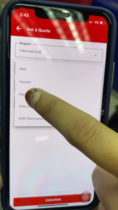 Friendly staff at Pos Malaysia showing how to use app to check for a quote and its limit