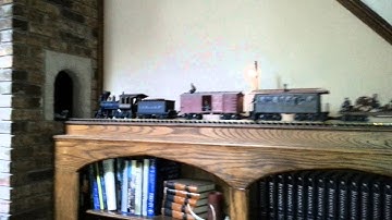 Model train tunnel through fireplace chimney.