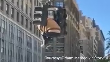 Man climbs onto traffic light in busy Midtown intersection