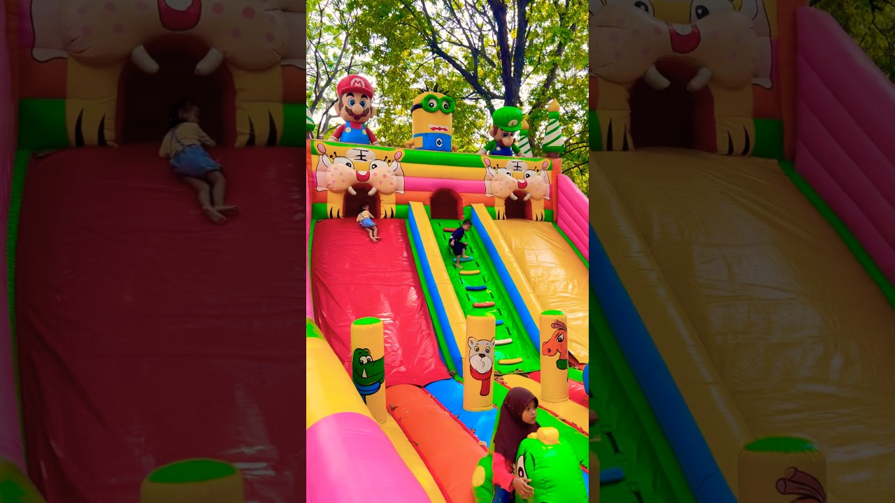 Naik balon hijau dinosaurus di wahana perosotan istana balon