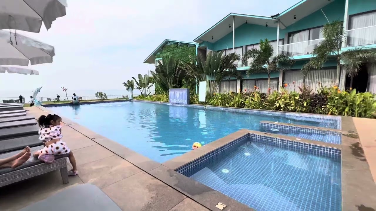Family Relaxing in outside swimming pool@ Tan & Sand beach resort Goa.